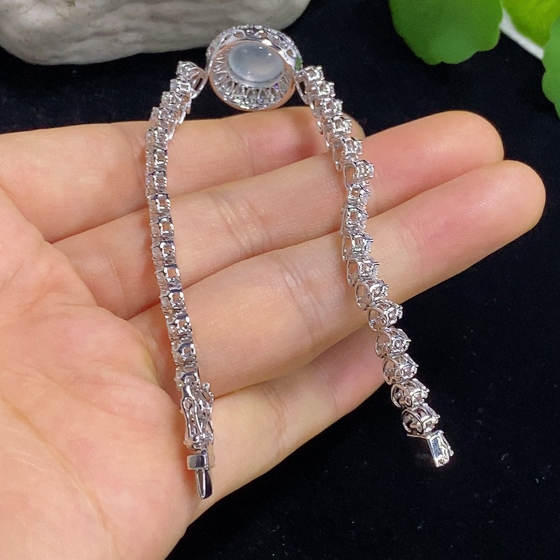 Jadeite cabochon bracelet in 18K gold with diamond accents, featuring a smooth, polished jadeite stone on a luxurious gold band.
