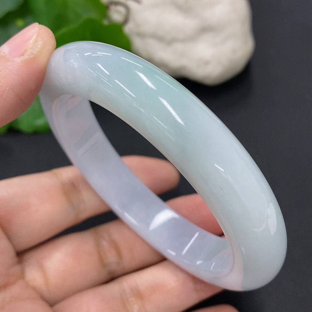 HUILIU HQ jadeite round bangle in size 56, weighing approximately 63.1g, showcasing smooth, polished green jade surface.