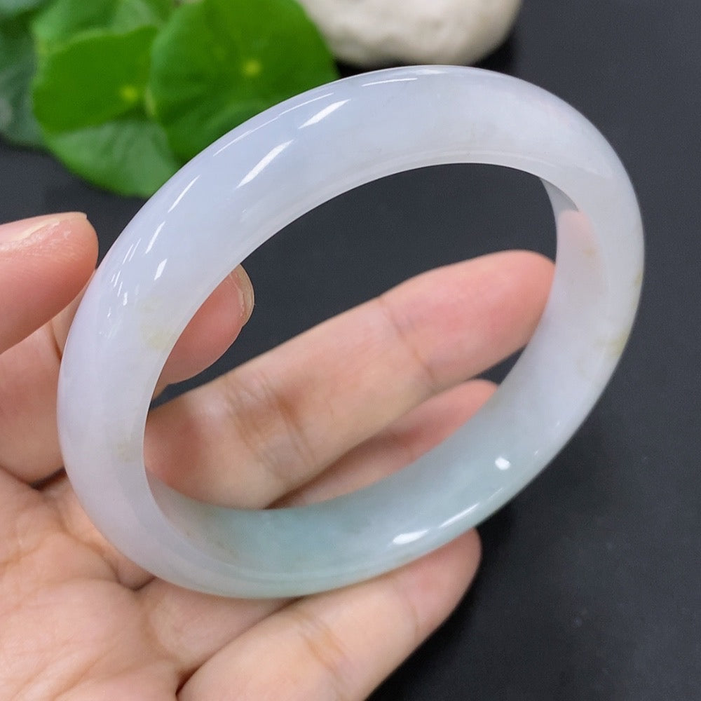 HKHQ jadeite round bangle with 53g weight and size 58.7, showcasing smooth, polished jade surface in natural light.