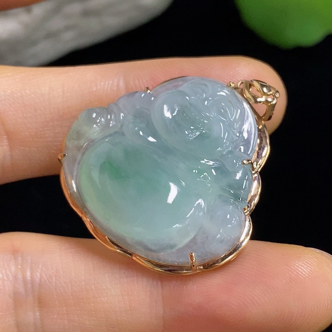 Jadeite Buddha pendant with 18k gold mounting, showcasing a detailed jade Buddha figure on a jewelry display.