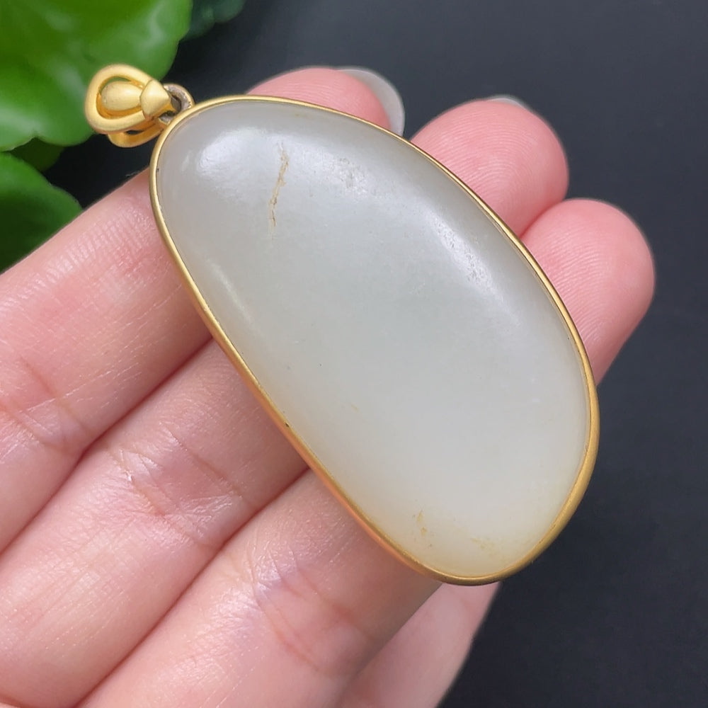 Hetian jade inlaid pendant with 18K gold setting from HKHQ, weighing 25.95g, featuring intricate craftsmanship and elegant design.