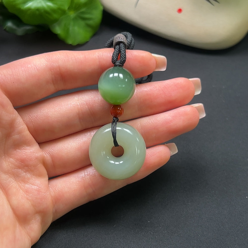 HKHQ Hetian Jade Peace Knot Pendant with Southern Red, 22.9g, featuring intricate carved design and attached rope.