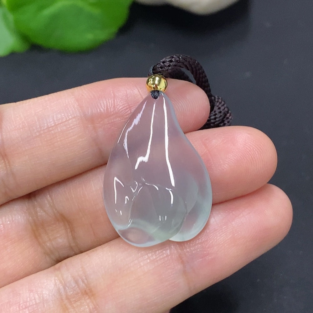 Jadeite freeform pendant with natural green jade, showcasing smooth, polished surface and attached rope for wearing.
