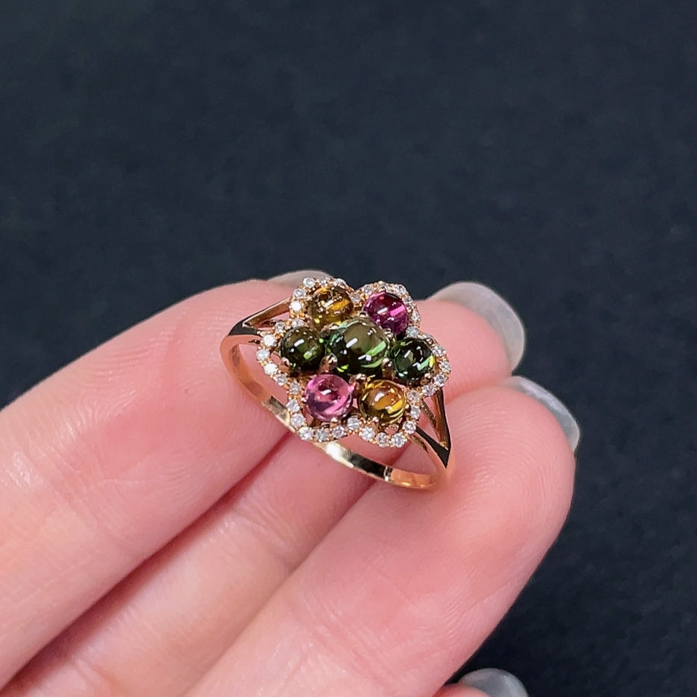 18K gold ring with inlaid tourmaline and diamond accents, showcasing intricate craftsmanship and vibrant gemstone details.