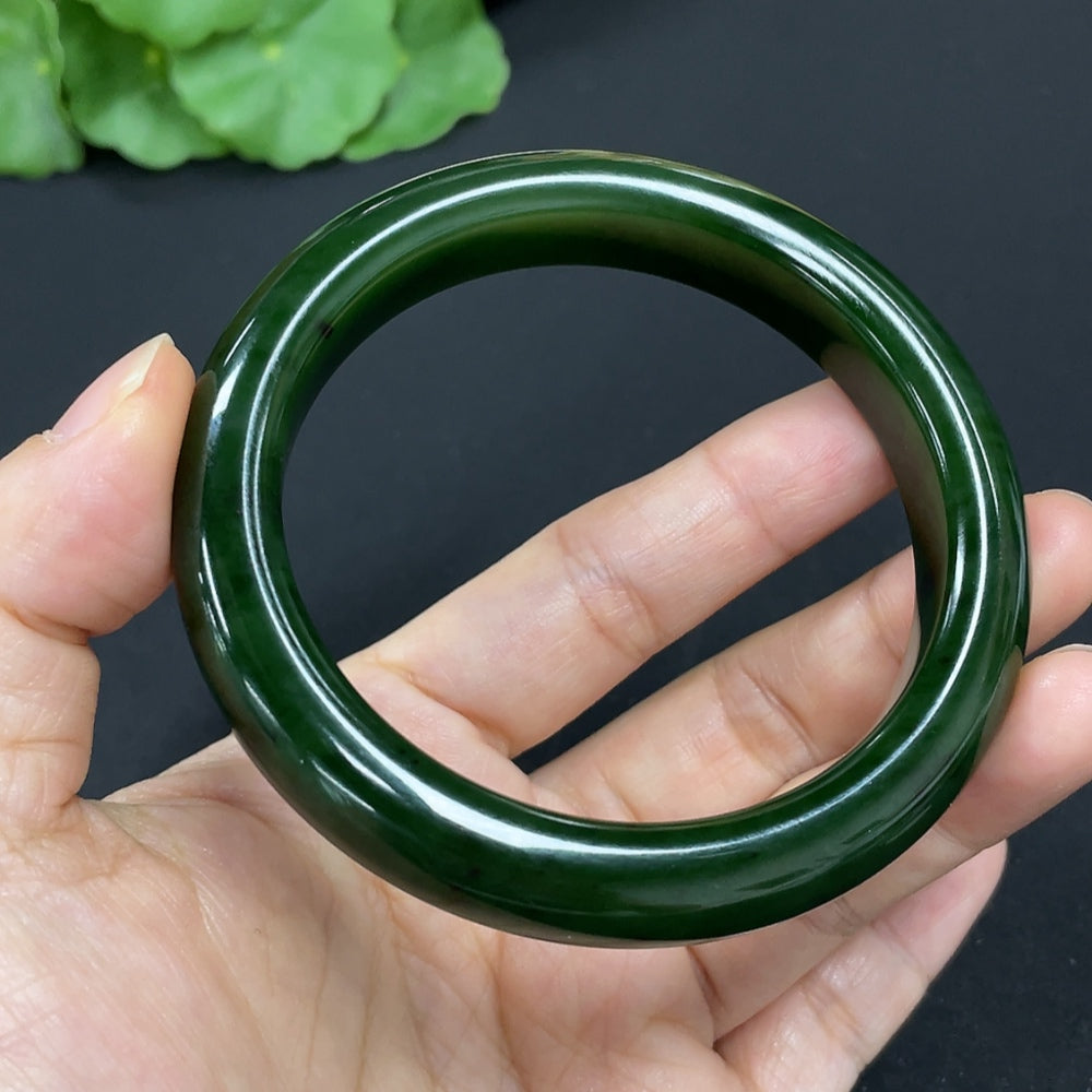 Green Hetian Jade round bangle bracelet from HKHQ featuring smooth, polished jade with a glossy finish on a plain background.