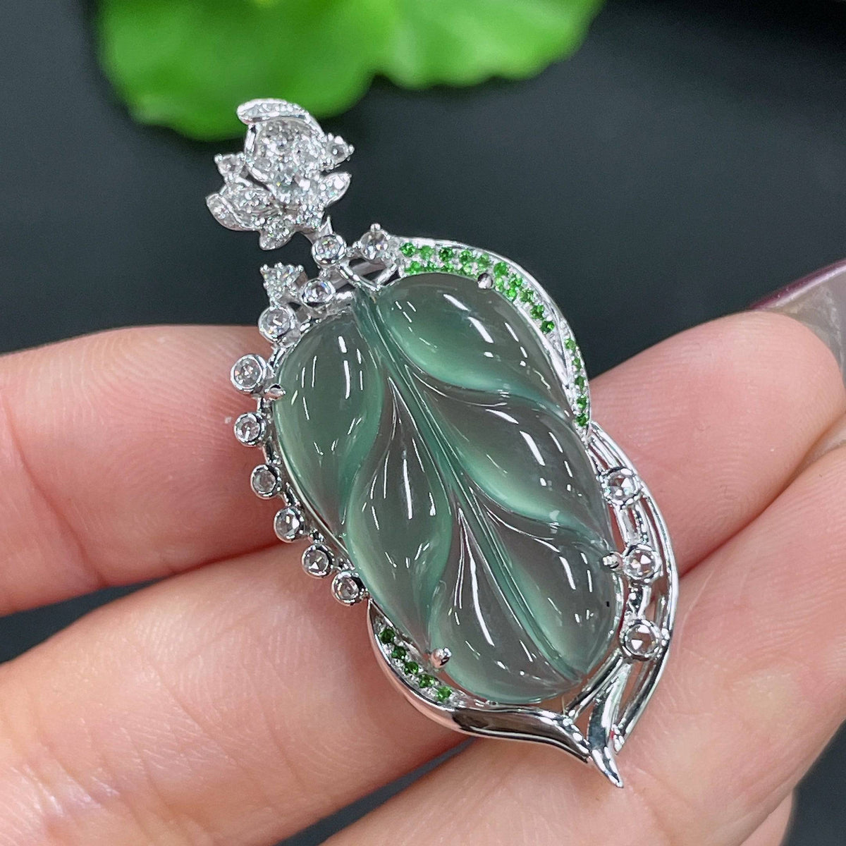 Jadeite leaf pendant with 18k gold inlay and diamond accents, crafted by HUILIU HQ, weighing approximately 6.7g.