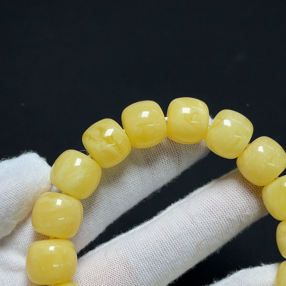 Amber Beeswax Bracelet by HKHQ showcasing a warm, natural amber color and smooth beads on an elastic band.