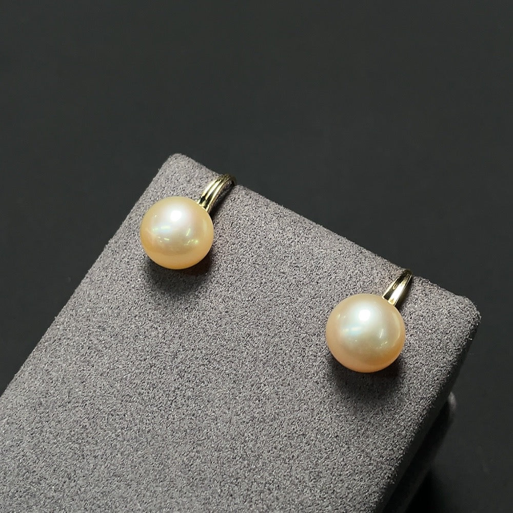 Saltwater pearl earrings with 18K gold settings by HKHQ, showcasing elegant pearl dangles on delicate gold hooks.