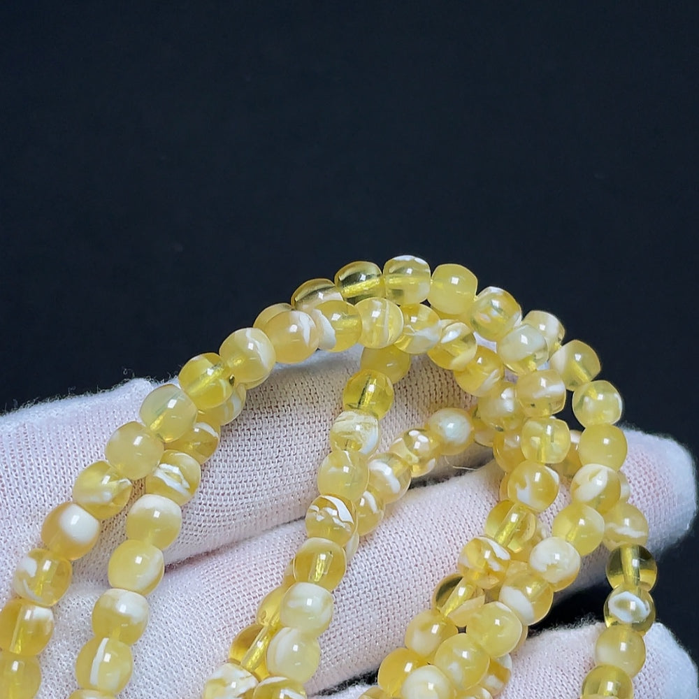 Amber beeswax bead strand with 5.5mm beads and non-natural accent stones, weighing approximately 14.32 grams, by HKHQ.