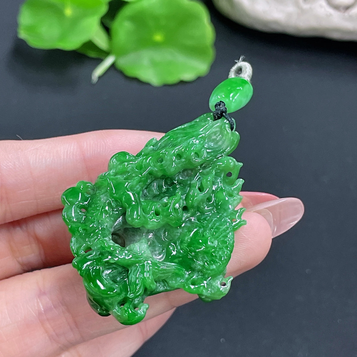 Jadeite dragon pendant from HKHQ, crafted in vibrant green jade, weighing approximately 23.97 grams, detailed dragon design.