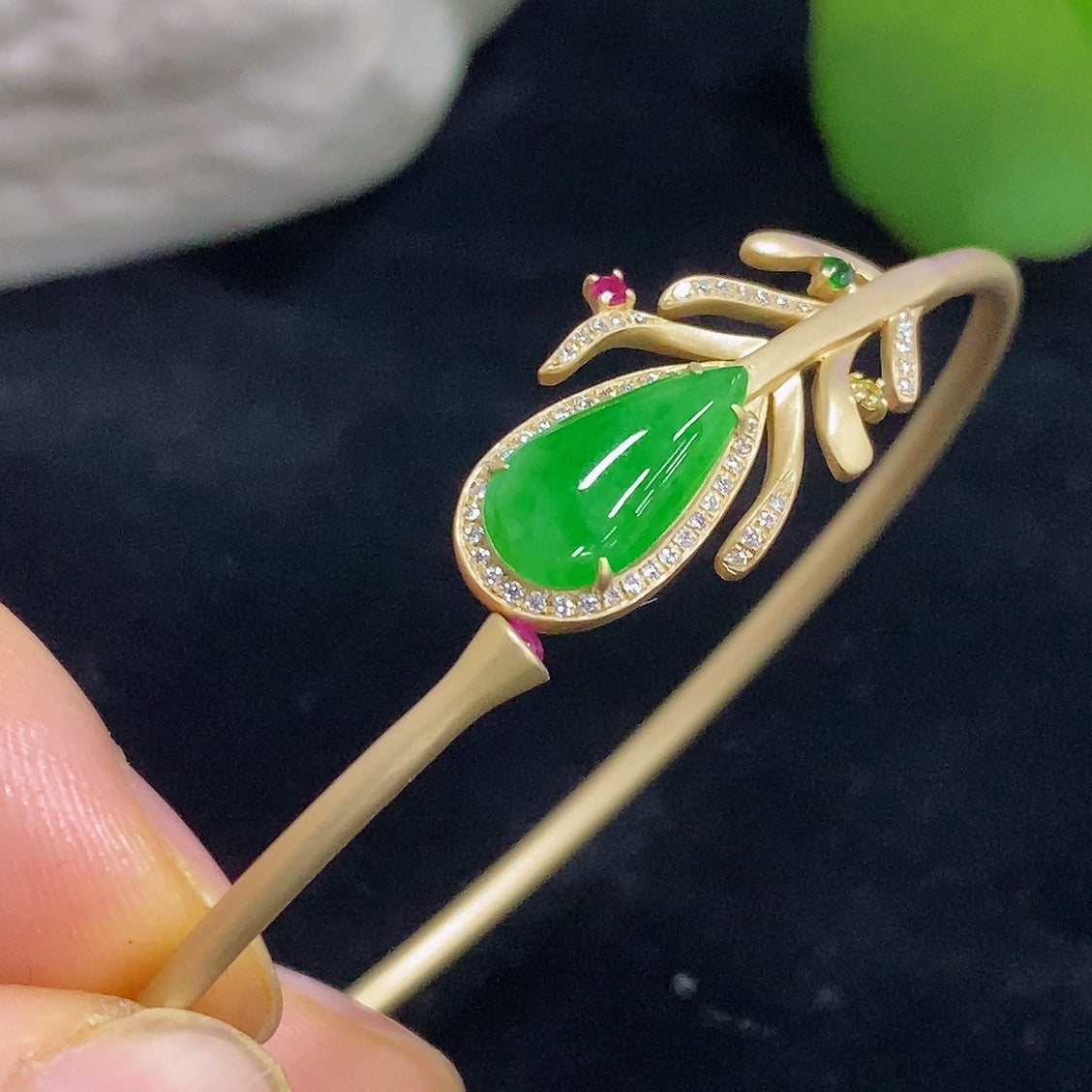 Jadeite bangle in 18K gold with colorless diamond accents, elegant bracelet with smooth jadeite and sparkling gemstones.