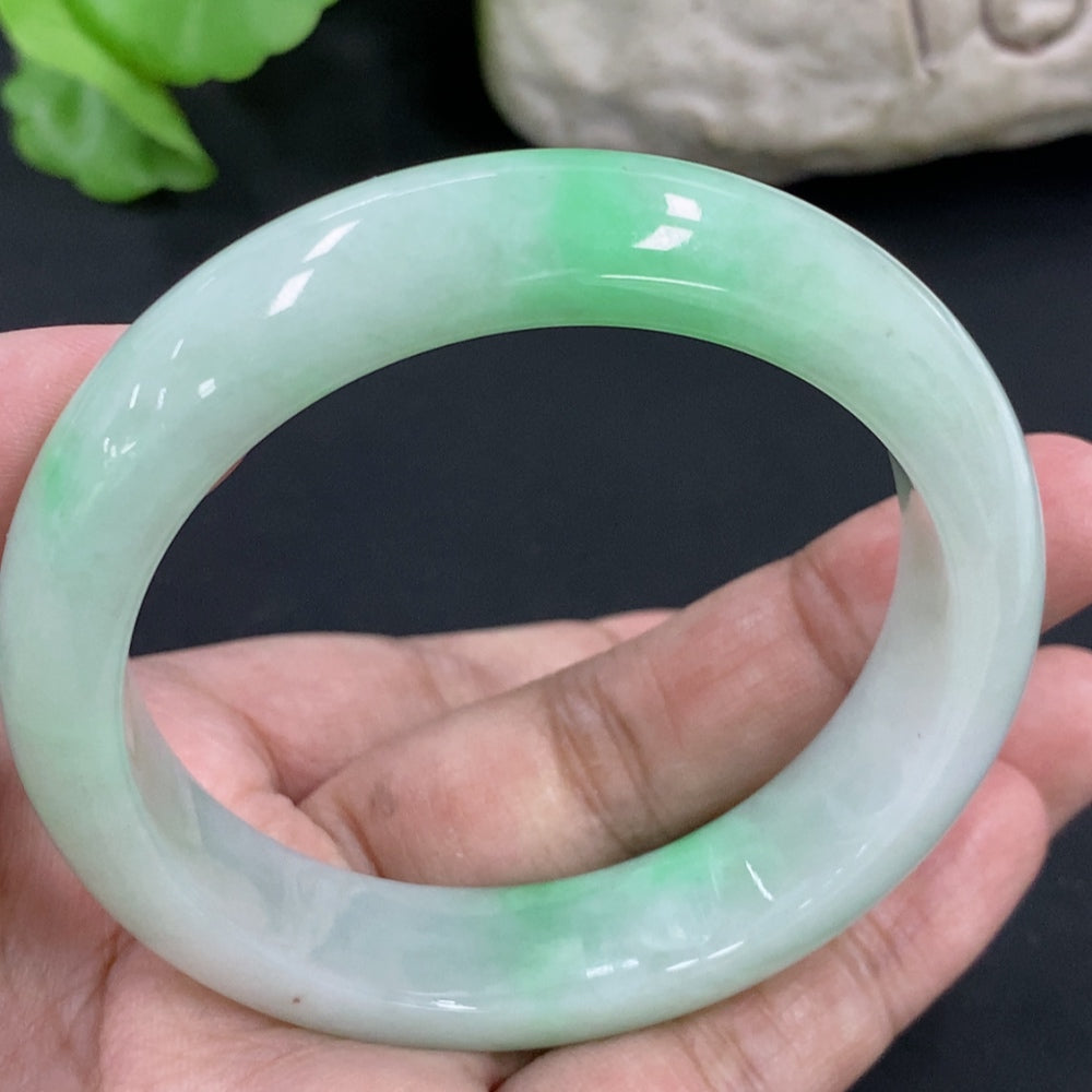 HKHQ jadeite round bangle in size 53.8 with a smooth, polished surface and a vibrant green hue, weighing 56.6 grams.