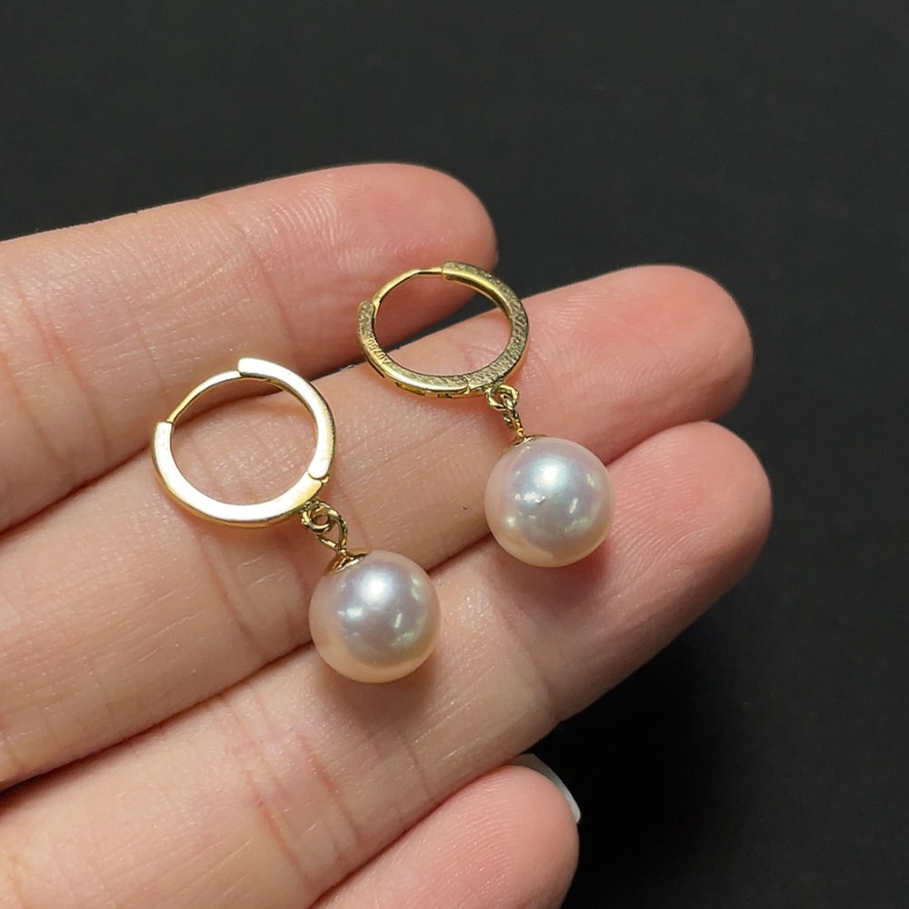 Saltwater pearl earrings with 18K gold setting from HKHQ, showcasing elegant pearl dangles on shiny gold hooks.