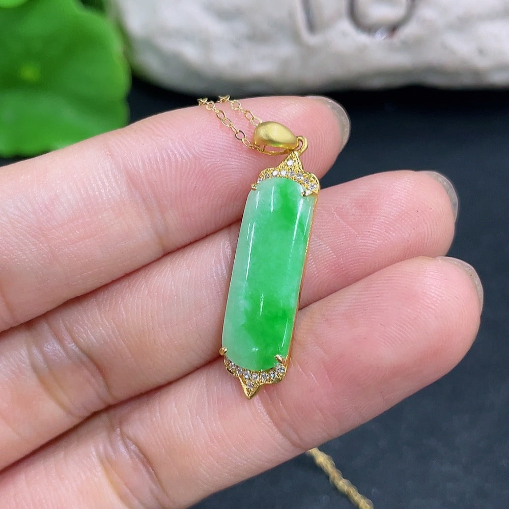 Jadeite pendant with 18K gold setting and diamond accents, displayed on a necklace chain.