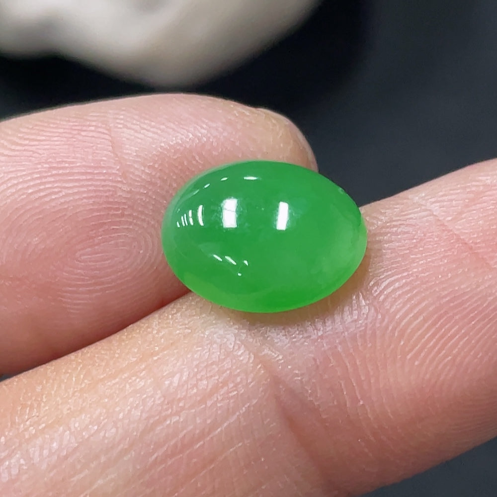 Smooth green jadeite cabochon from HUILIU HQ, approximately 0.67g, showcasing polished, rounded jade gemstone for jewelry or collection.