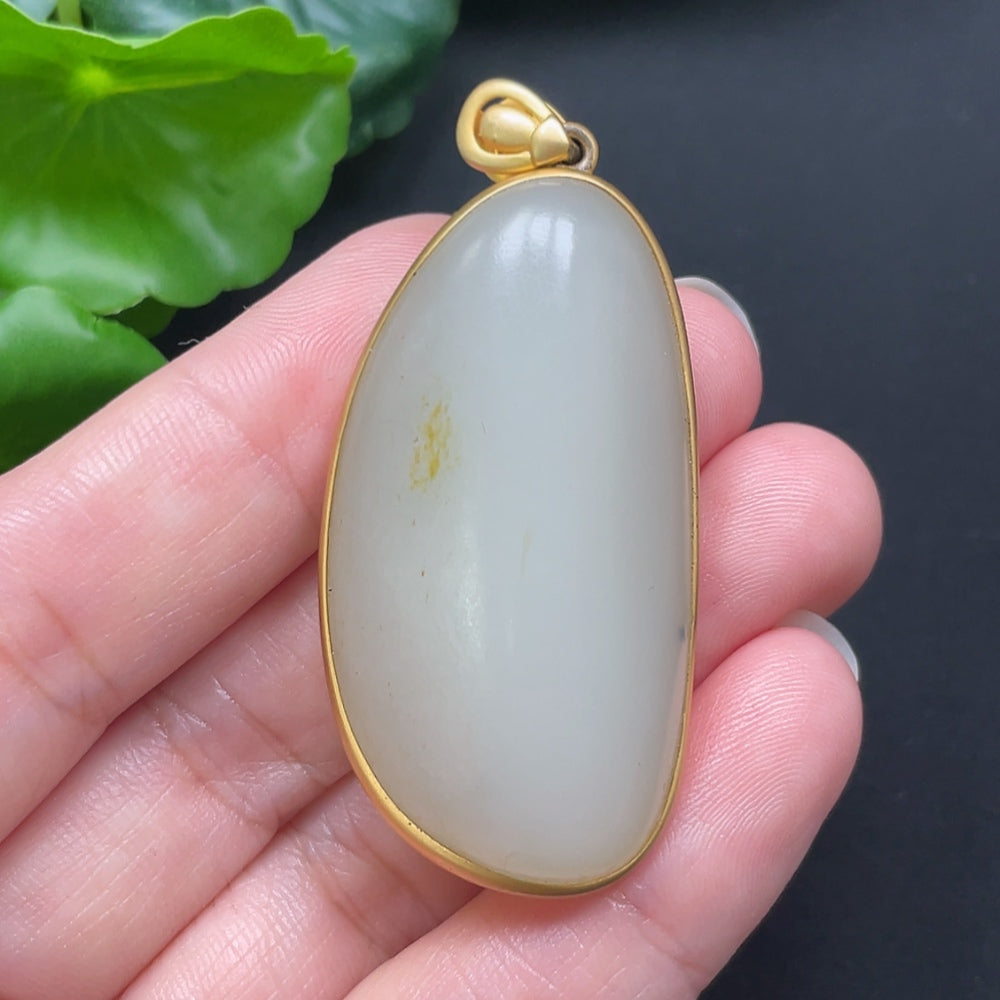 Hetian jade inlaid pendant necklace with 18K gold setting, crafted by HKHQ, featuring a polished jade gemstone on a delicate chain.