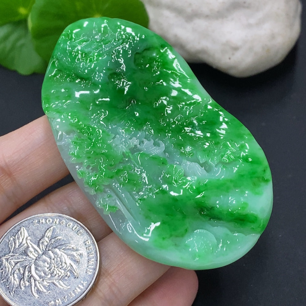 Jadeite landscape pendant from HKHQ featuring intricate carved jade in a natural landscape design, weighs approximately 65.3 grams.
