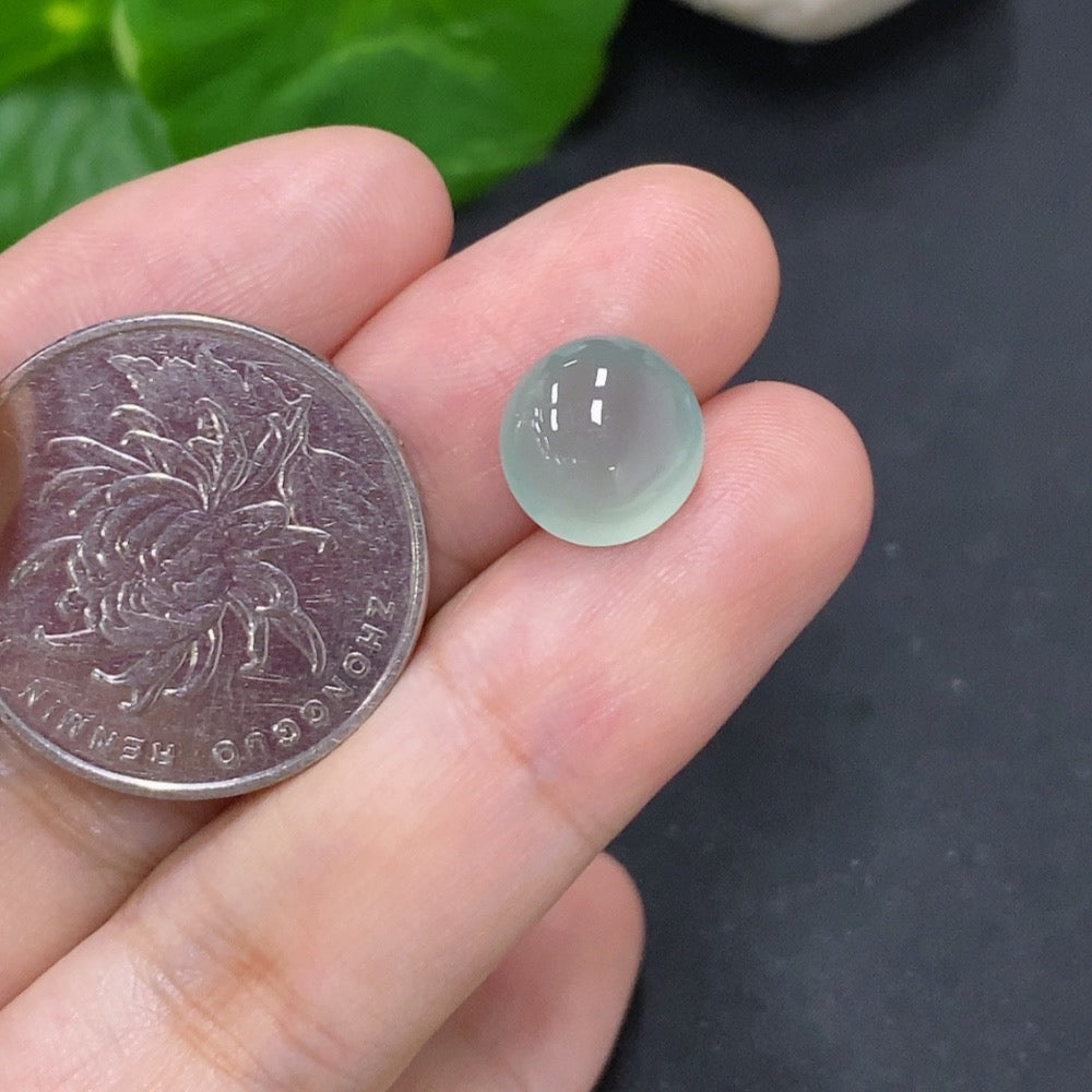 Jadeite cabochon jewelry piece from HKHQ, 0.8g, smooth polished green gemstone with natural luster and rounded shape.