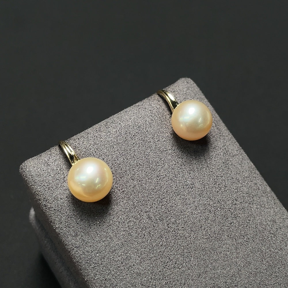 Saltwater pearl earrings with 18K gold hooks, featuring smooth, round pearls on elegant jewelry hooks.