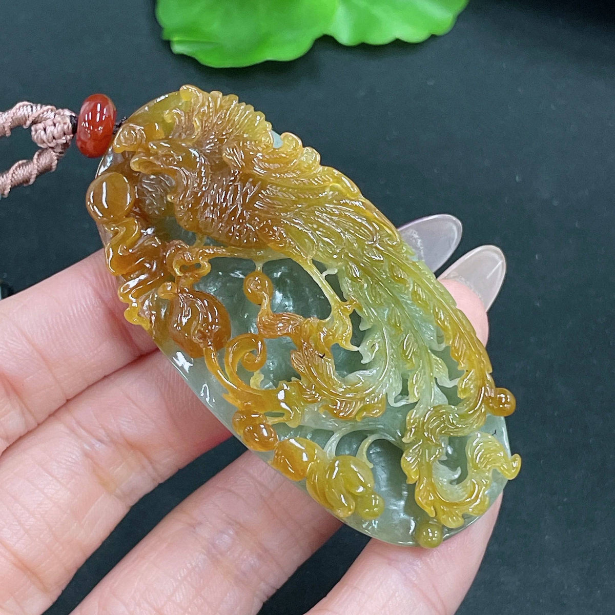 Jadeite pendant featuring a phoenix design on a cord, crafted by HUILIU HQ, weighs approximately 45.37 grams.