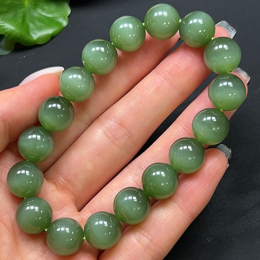HKHQ Hetian jade bracelet with 11.8mm smooth round beads, showcasing a polished green gemstone design.