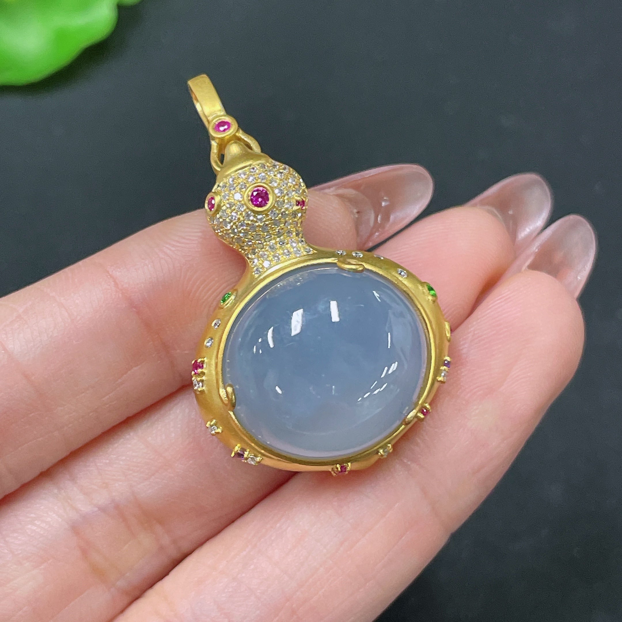 Jadeite pendant with 18k gold setting and colorless diamond accents, crafted by HUILIU HQ, shown against a neutral background.