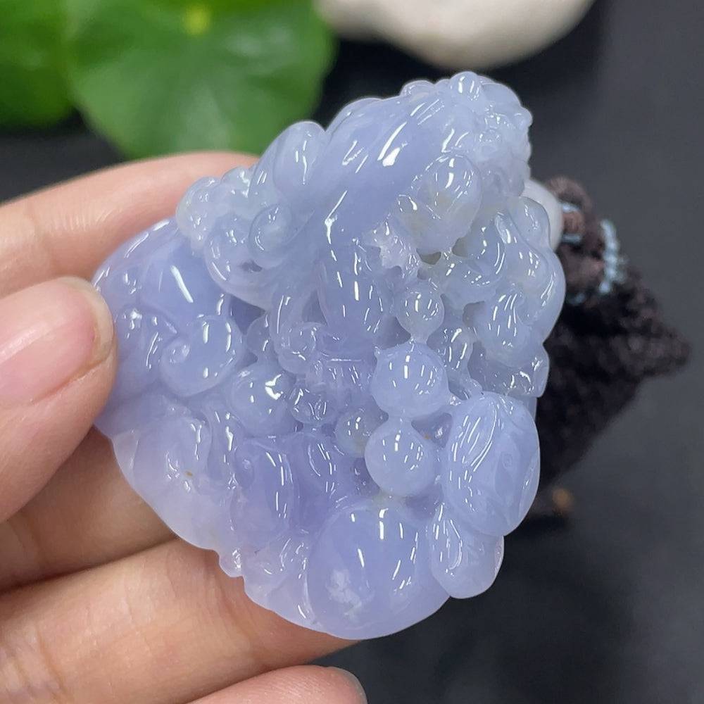 Huiliu certified jadeite pendant featuring a polished, green jade stone with intricate carvings on a delicate cord.