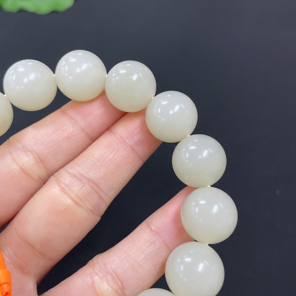 HKHQ Hetian Jade bracelet with 13.9mm beads, showcasing smooth green jade stones on a neutral background.
