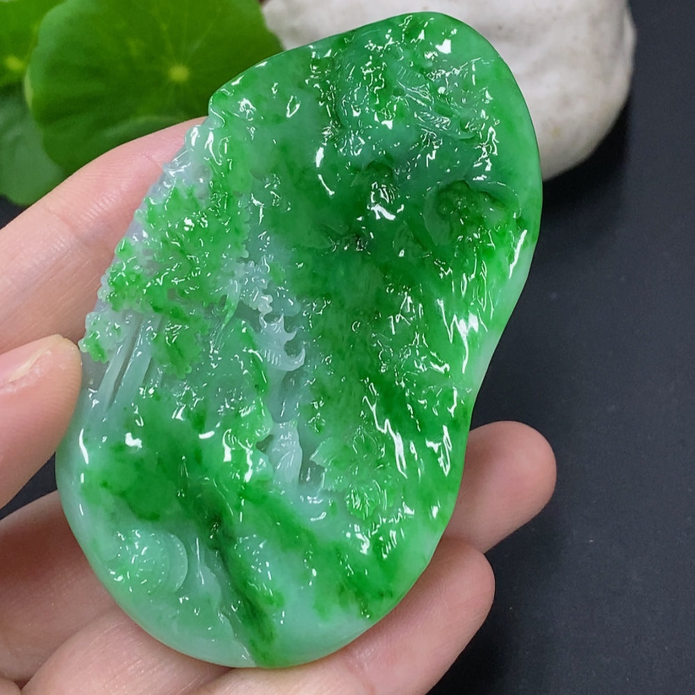 Jadeite landscape pendant from HKHQ showcasing a detailed carved jade pendant with natural green and white hues.