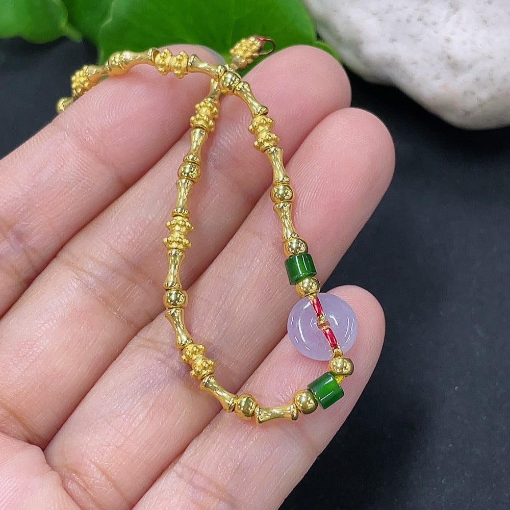 Jadeite inlaid bracelet with mixed gold components, featuring intricate gold accents and a smooth jadeite surface.