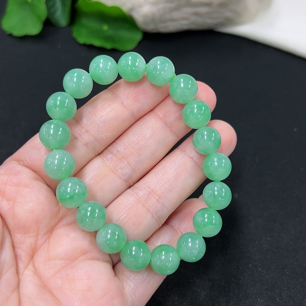 Jadeite bracelet with 9.5mm beads, approximately 28g, featuring smooth green jade stones, from HKHQ.