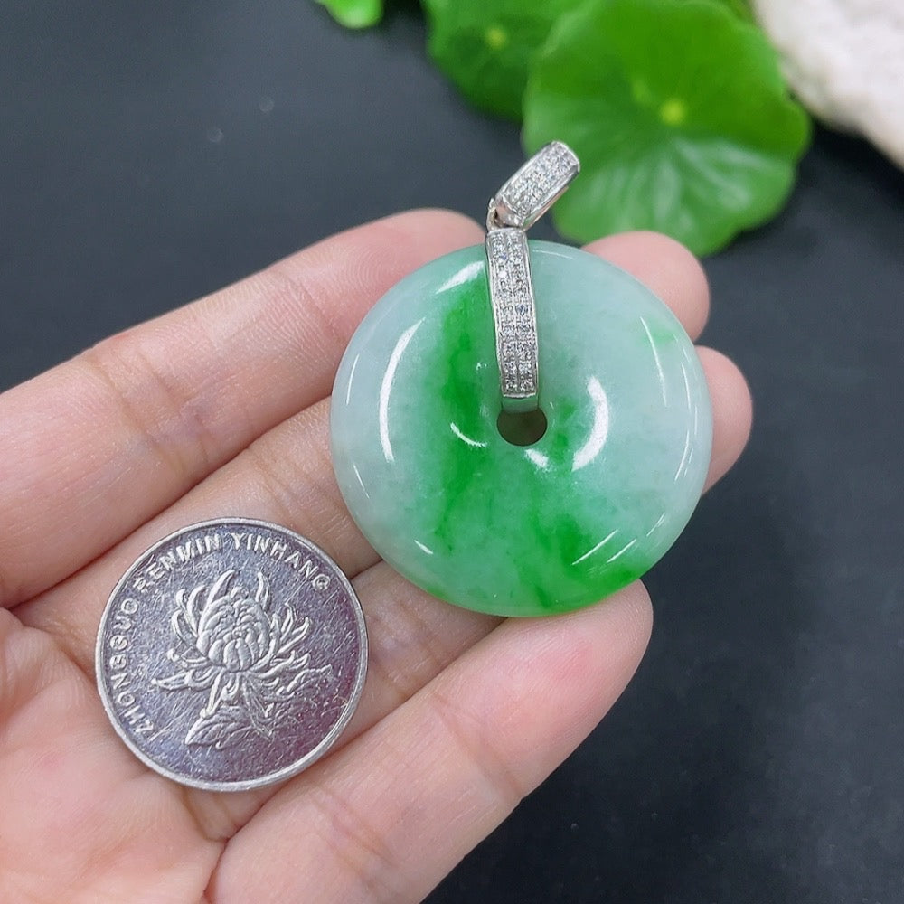 Jadeite pendant with peace knot design, 18k gold accents and diamond details, showcasing a smooth, polished jade surface.