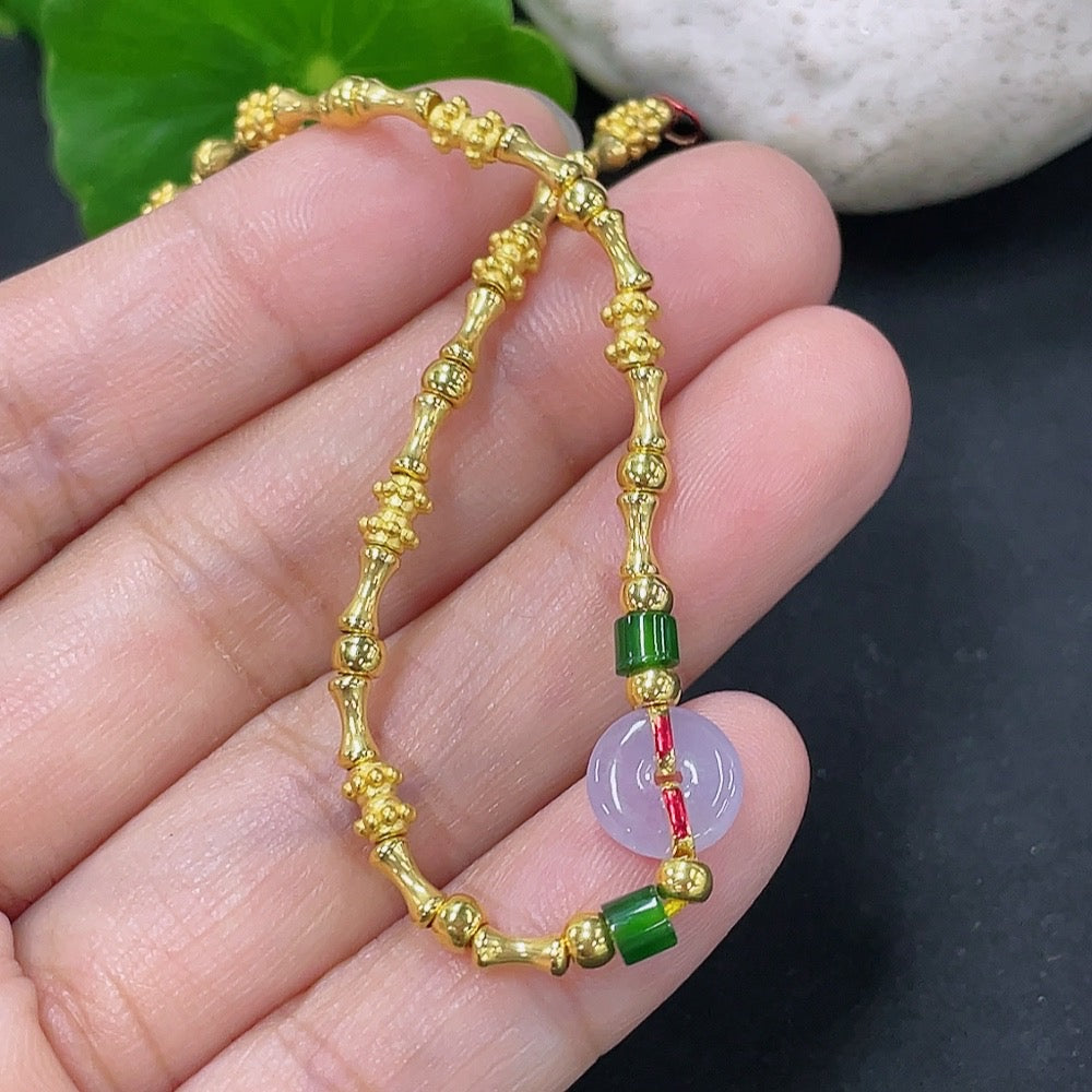 Jadeite inlaid bracelet with mixed gold components, featuring intricate gold accents and a smooth jadeite surface.