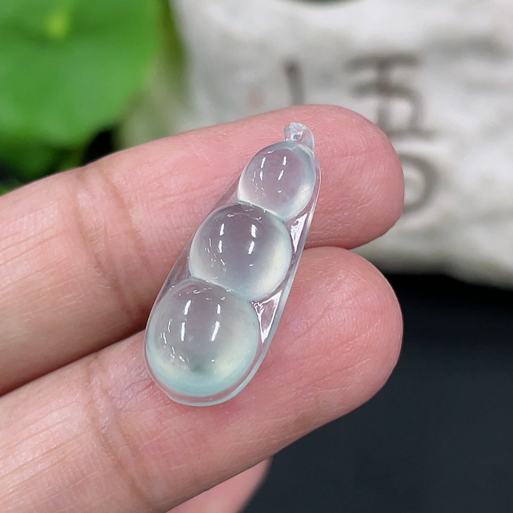 Close-up of HKHQ jadeite auspicious bean inlay piece, weighing approximately 1.88g, showcasing smooth green jade with intricate details.