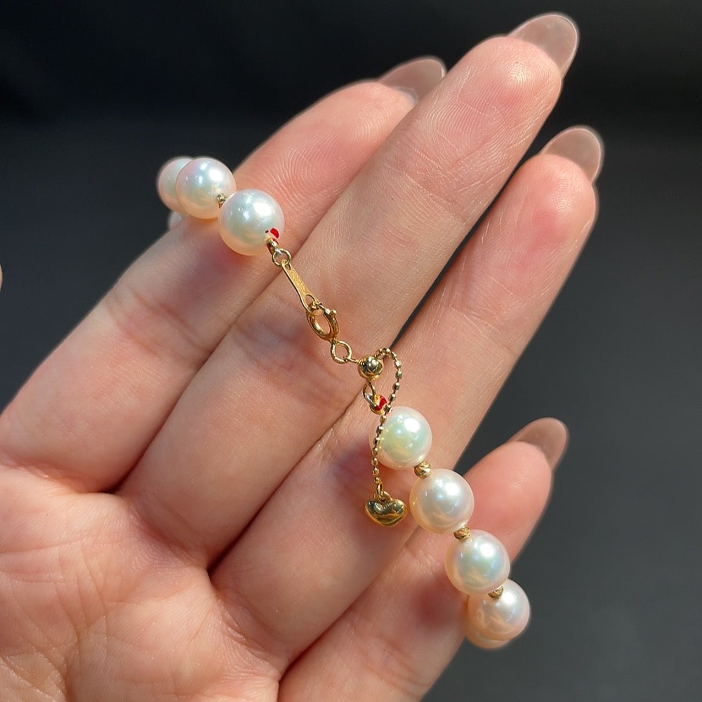 Seawater pearl bracelet with red-marked pearls on non-gold string, 18k gold accents, 7.1mm size, 10.15g weight, by HKHQ.