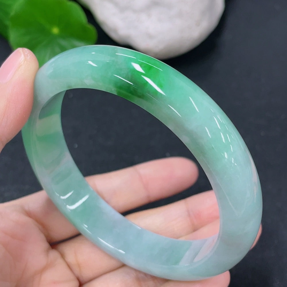 HKHQ jadeite round bangle, size 57.5mm, weighing approx. 56.35g, showcasing the smooth, polished green jade surface.