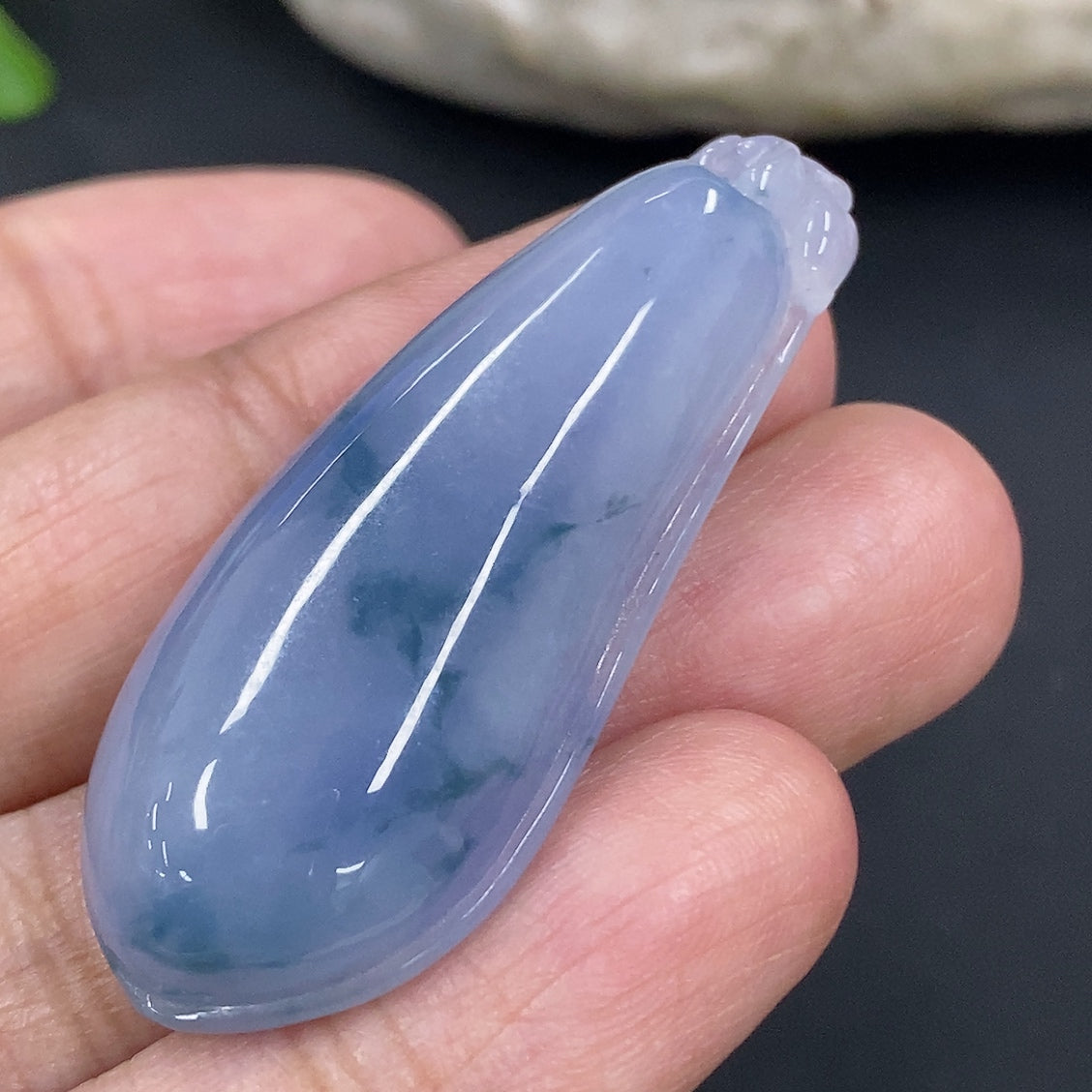 Jadeite auspicious gourd pendant from HKHQ, showcasing a smooth, polished green jade piece with intricate carvings.