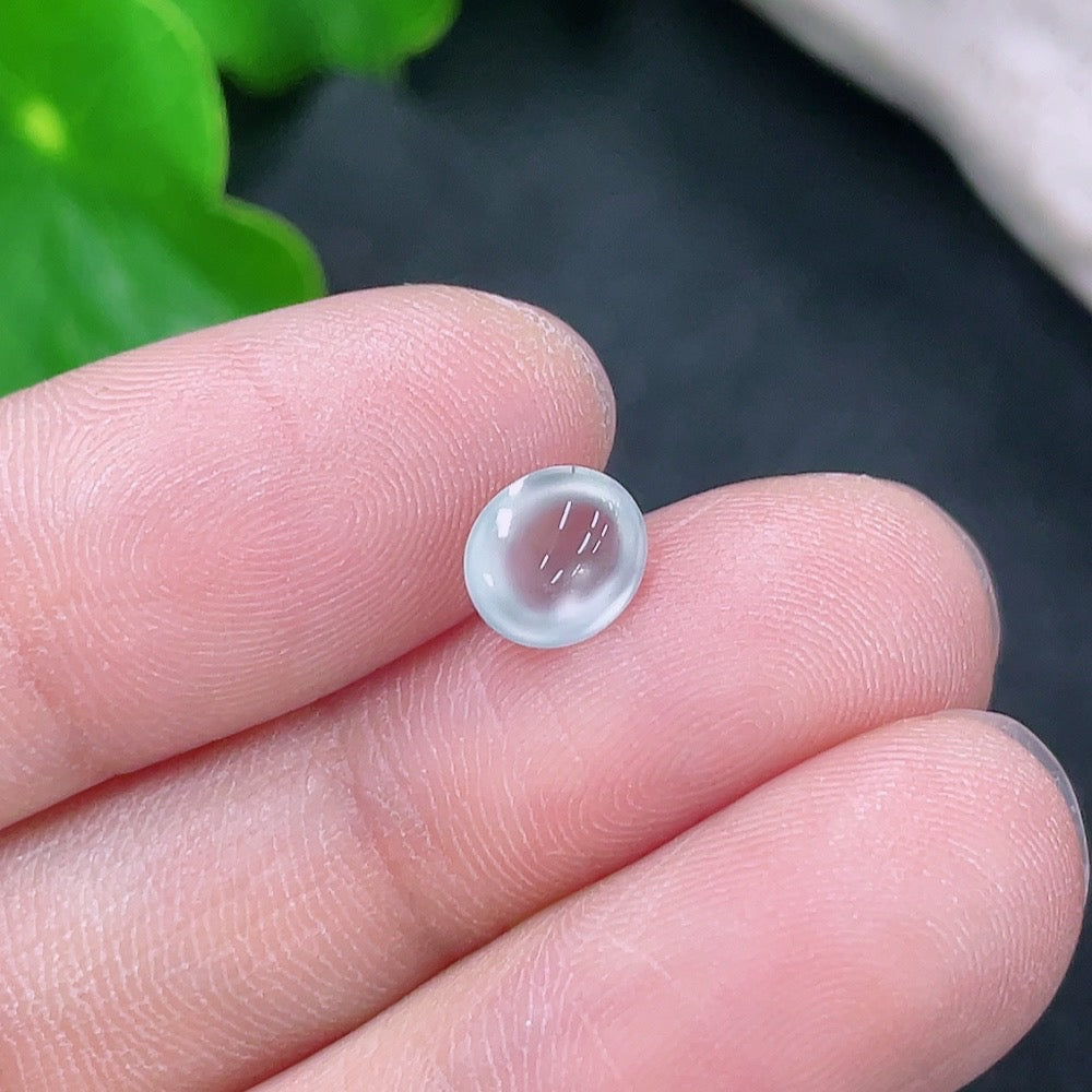 Close-up of a small jadeite cabochon jewelry piece weighing 0.19g, showcasing smooth, polished green gemstone details.