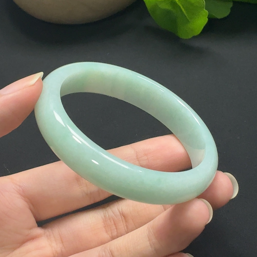 Jadeite round bangle in size 55.8, weighing approximately 45.69g, featuring smooth polished jade surface and vibrant green color.