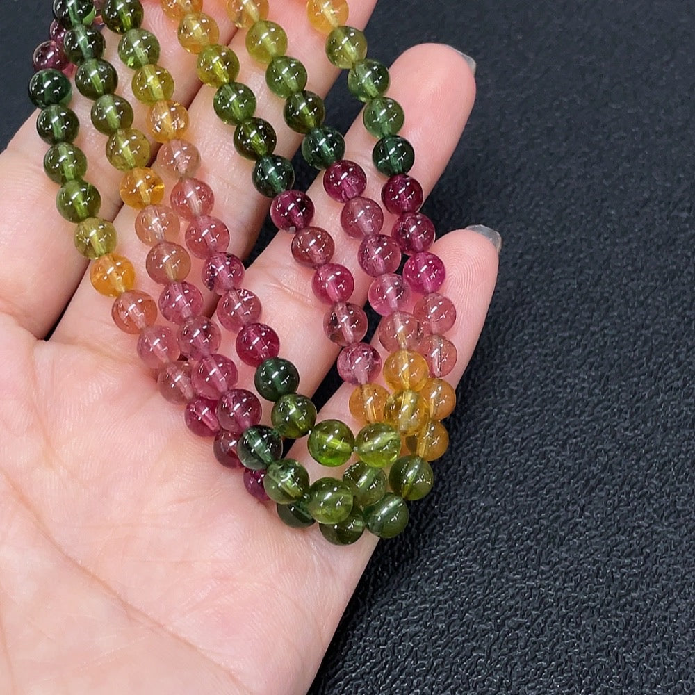 Tourmaline bead strand necklace by HKHQ featuring vibrant, polished multicolored gemstone beads on a delicate string.