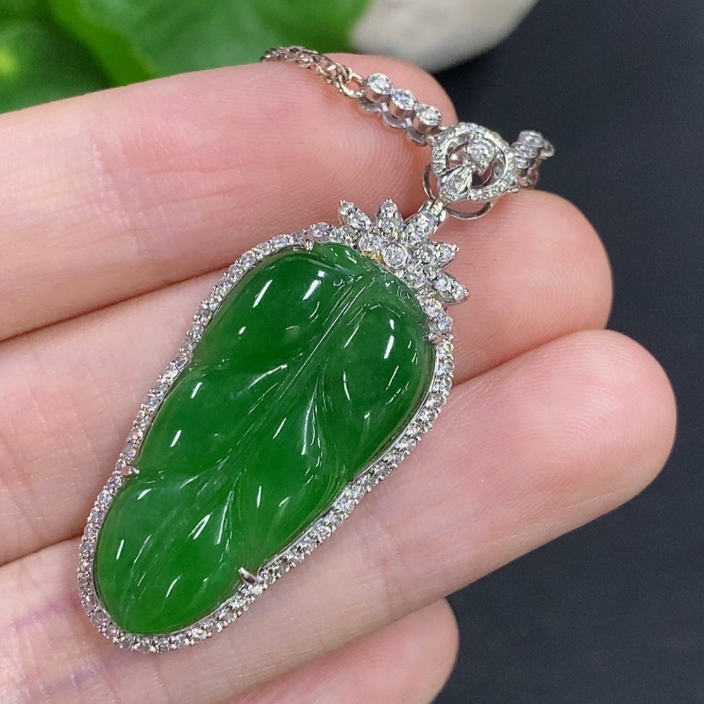 Jadeite leaf pendant with 18K gold accents and diamond details, hanging on a chain, showcasing intricate craftsmanship and natural jade color.