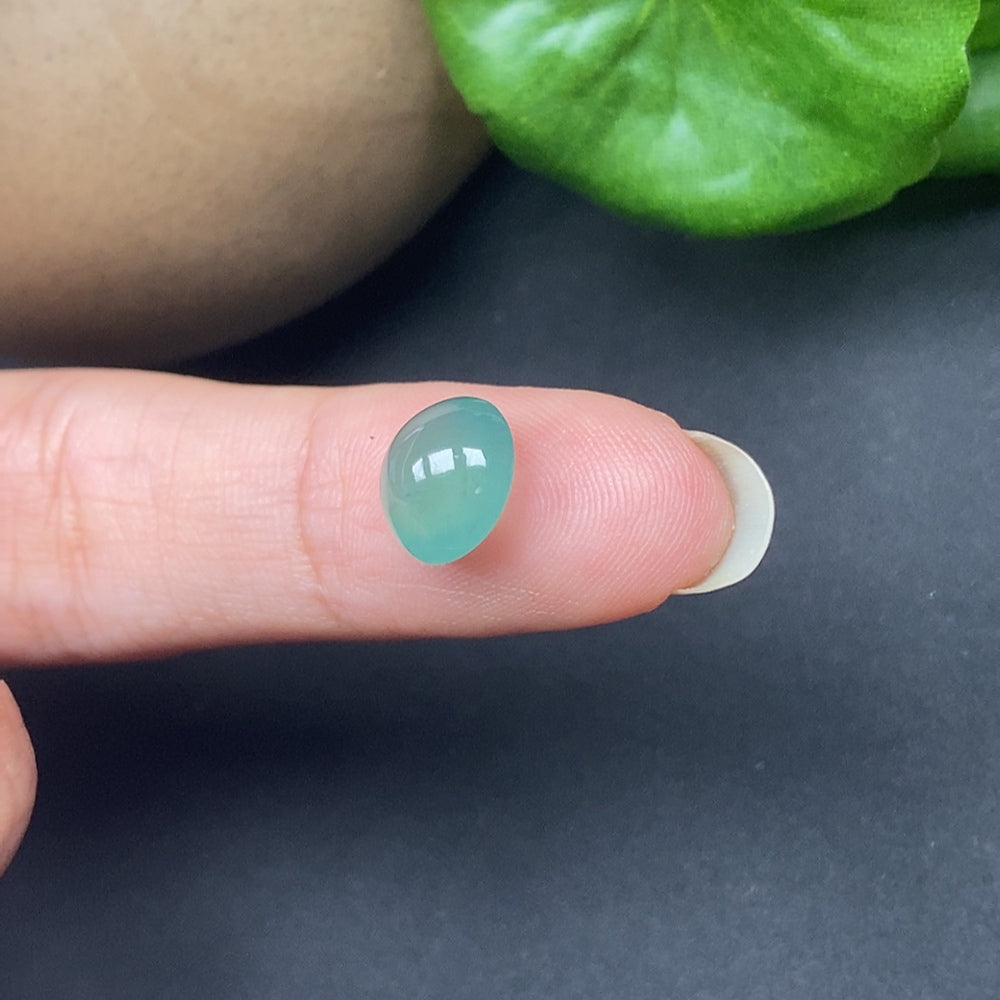 Close-up of HKHQ jadeite cabochon inlay showing vibrant green jade with smooth polished surface and natural stone texture.