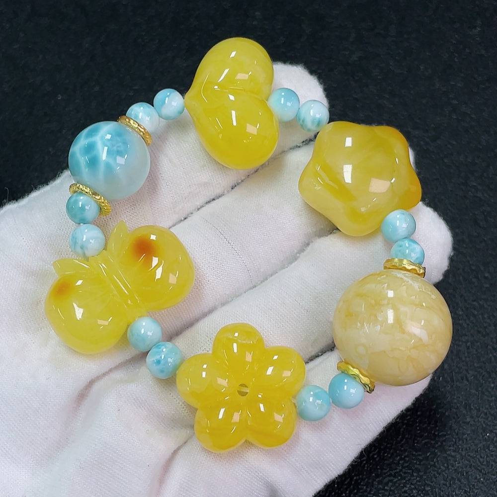 Huiliu Amber Beeswax bracelet with larimar stone and organic matter, showcasing natural textures and vibrant blue hues.