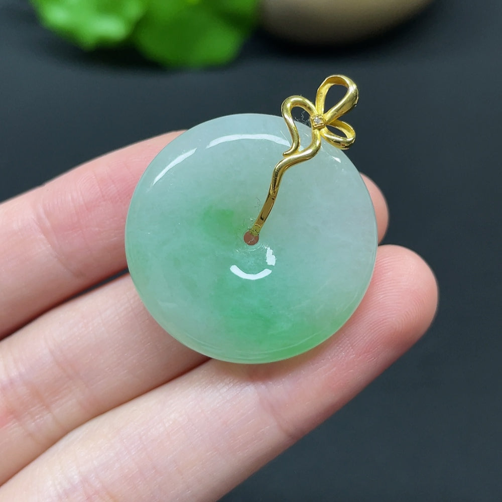 Jadeite Peace Knot pendant with 18k gold, diamond side stones, showcasing intricate inlay design and polished finish.