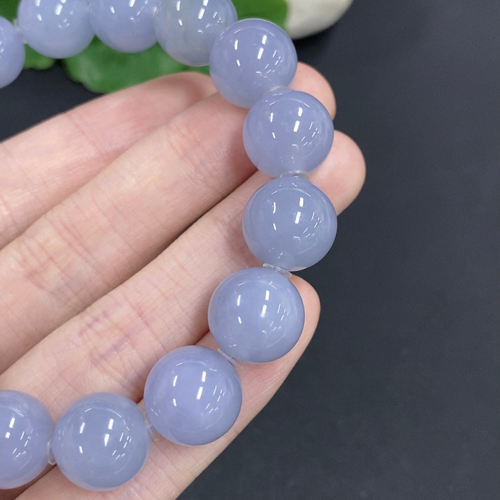 HKHQ jadeite bracelet weighing 56.7g with 12.7mm beads, showcasing smooth, polished green jade stones on a white background.