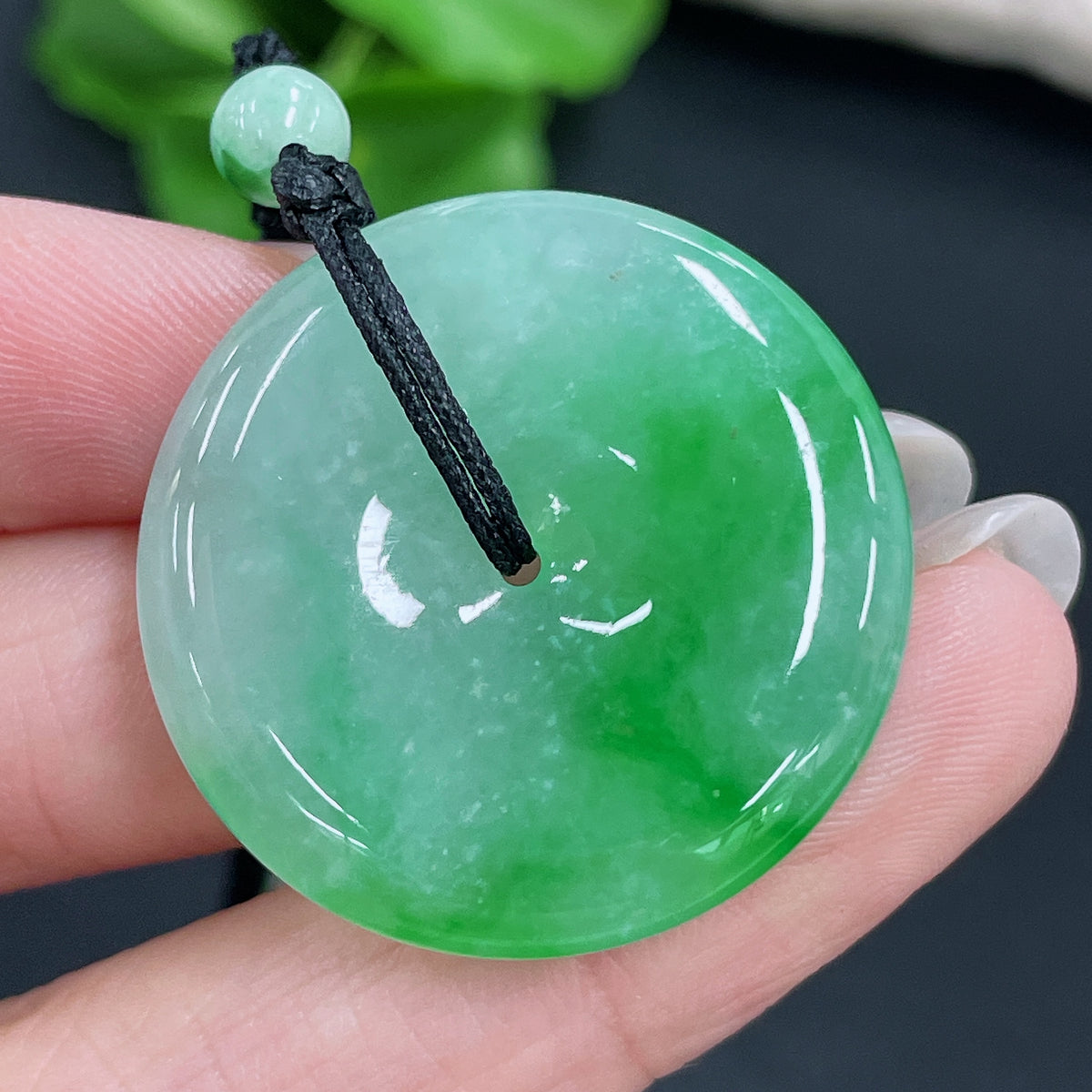 Jadeite pendant with peace knot design on cord, HKHQ jade jewelry, non-grade A beads, total weight 17.53g, close-up view.