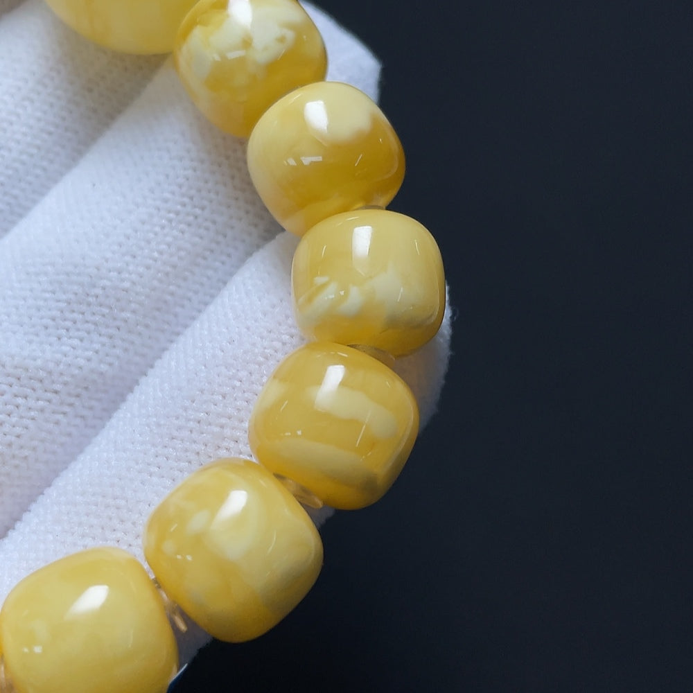 Amber beeswax bracelet by HKHQ with visible repairs, measuring 11.4-18.8mm, weighing approximately 19.22g, natural and handcrafted.