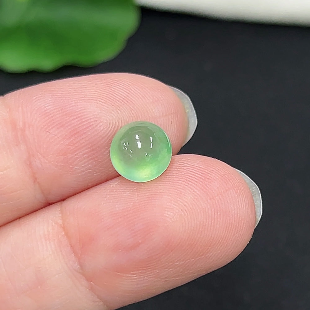 Small jadeite cabochon jewelry piece from HKHQ, showcasing smooth, polished green gemstone with subtle natural variations.