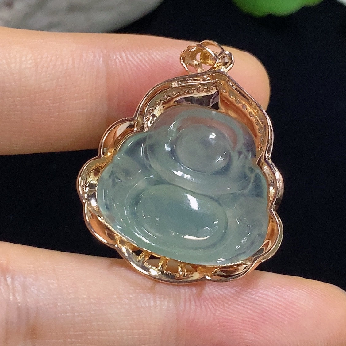 Jadeite Buddha pendant with 18k gold and diamond accents, showcasing a detailed carved jade figure on a delicate chain.