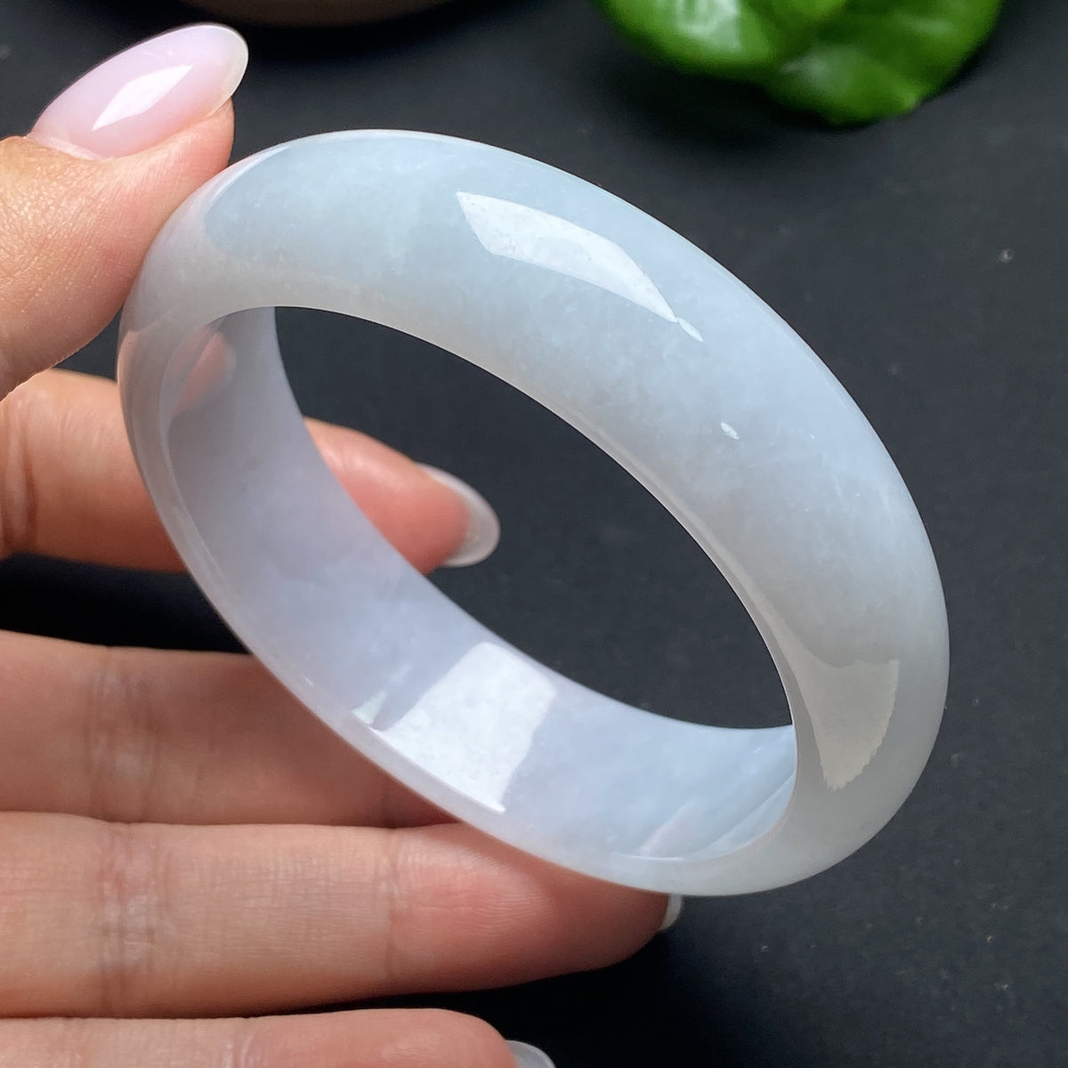 HKHQ jadeite round bangle showcasing smooth, polished green jade with a classic circular design on a plain background.